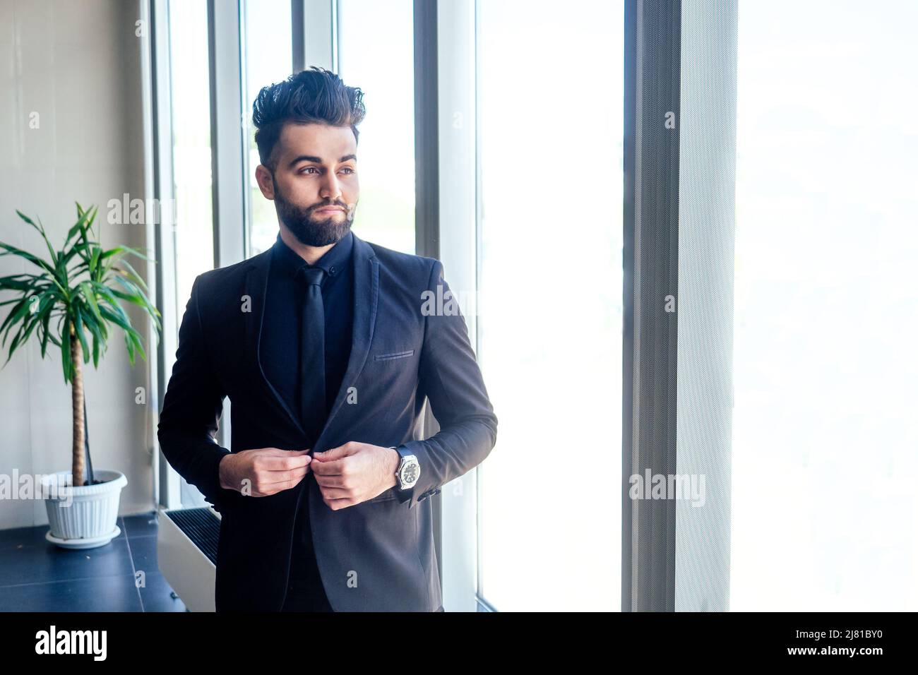 Homme d'affaires arabe dans les fenêtres en verre de l'aéroport de Dubaï Banque D'Images