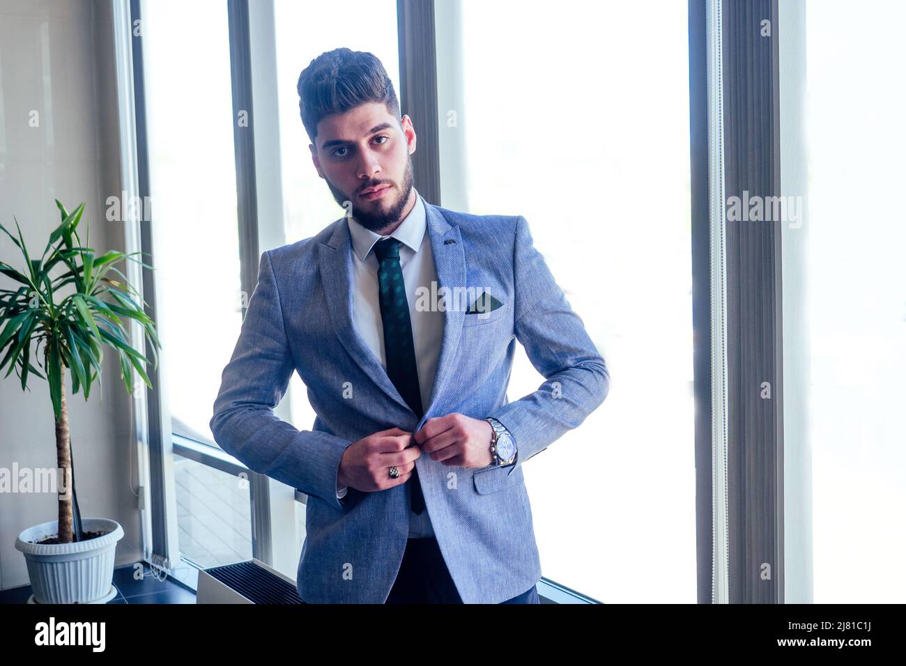 Homme d'affaires arabe dans les fenêtres en verre de l'aéroport de Dubaï Banque D'Images