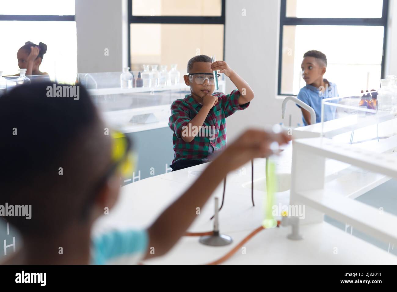 Les élèves afro-américains de l'élémentaire effectuent des expériences scientifiques pendant la classe de chimie Banque D'Images