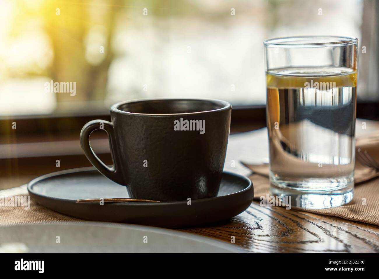 tasse de café ou thé et un verre d'eau sur table en bois dans le café. Banque D'Images