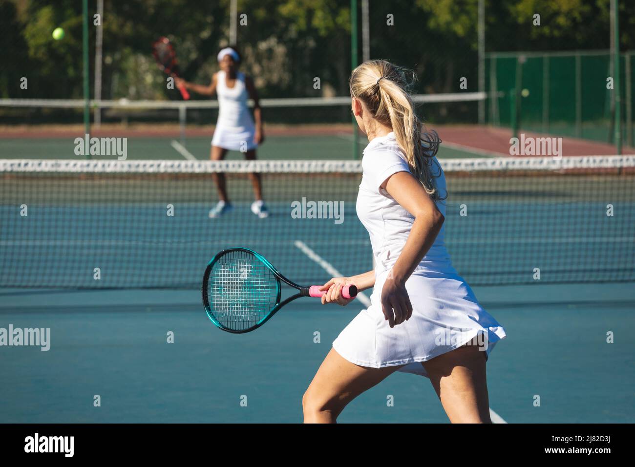 Athlète de race blanche en jouant au tennis avec un concurrent afro-américain sur le terrain Banque D'Images