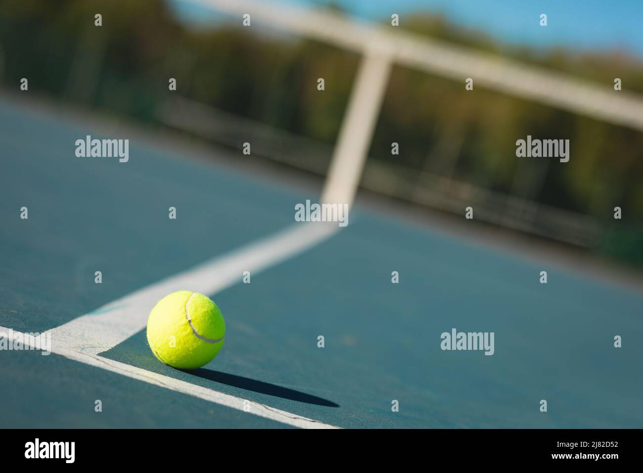 Gros plan de la balle de tennis verte en ligne sur un court vide pendant la journée ensoleillée Banque D'Images