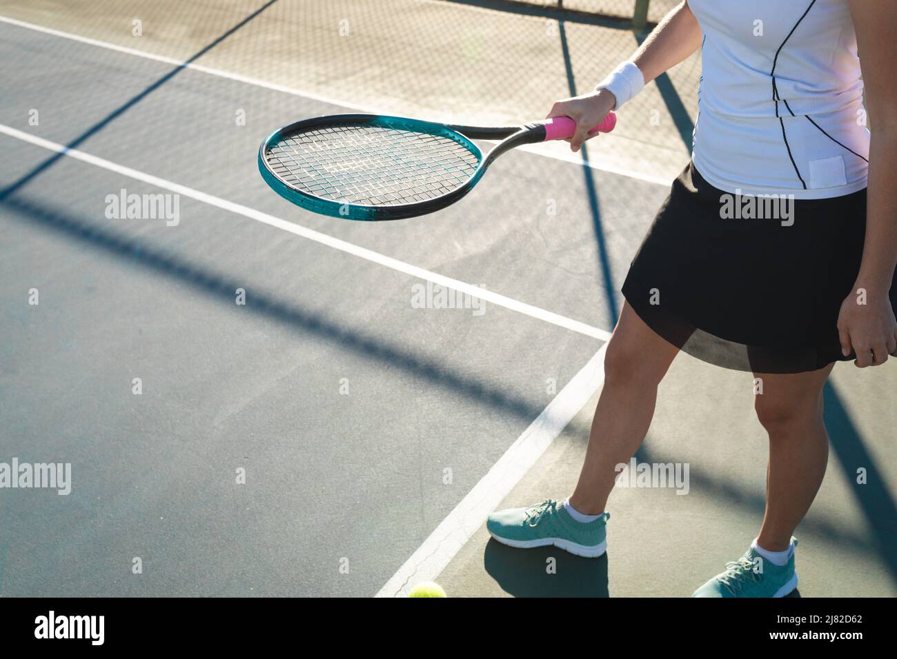 Petite section de jeunes femmes caucasiennes jouant sur le court de tennis le jour ensoleillé Banque D'Images