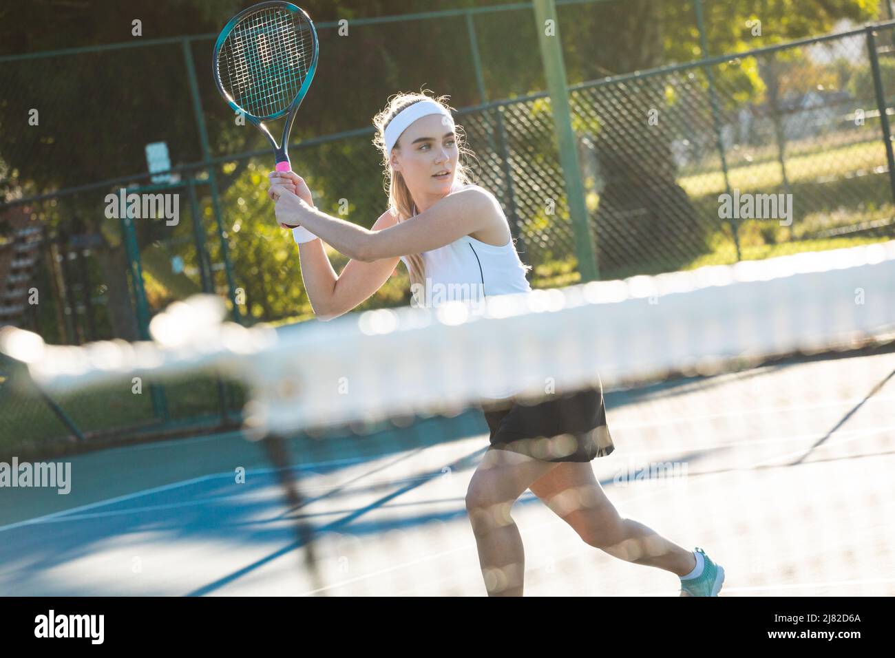 Jeune magnifique athlète caucasien jouant sur un court de tennis par beau soleil Banque D'Images