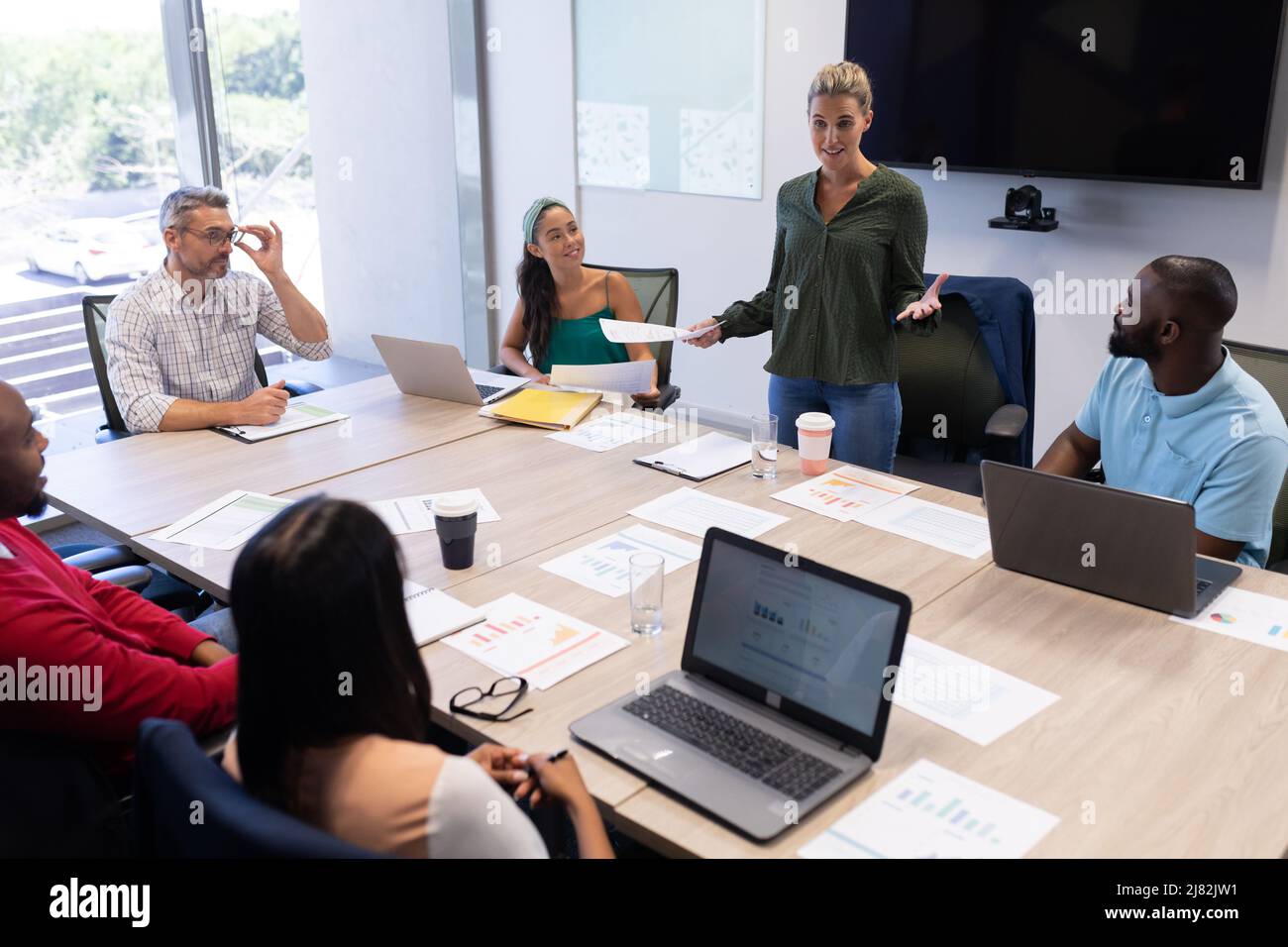 Femme d'affaires caucasienne souriante expliquant la stratégie lors d'une réunion en salle de réunion sur le lieu de travail Banque D'Images