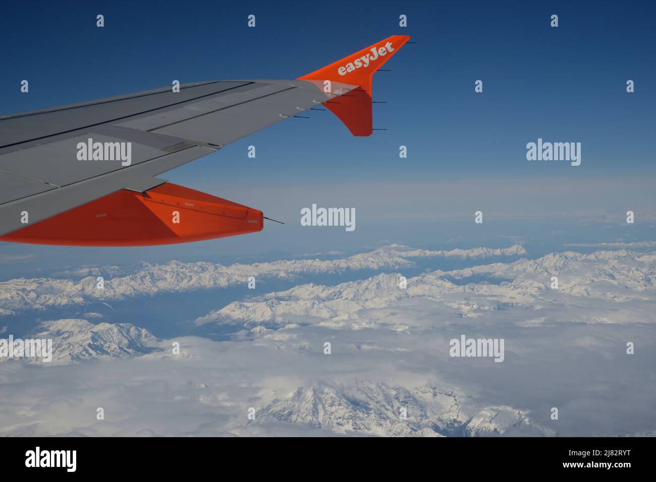 Vue depuis la fenêtre d'un avion d'une aile EasyJet et des Alpes européennes ci-dessous. Banque D'Images