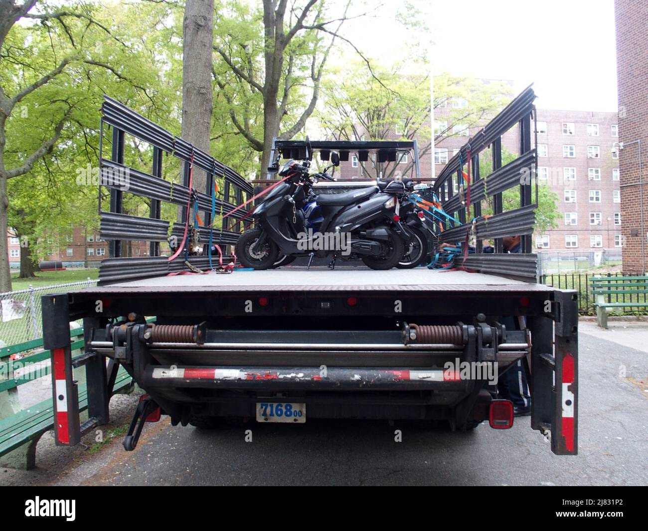 12 mai 2022, New York, New York, États-Unis : 12 mai 2022 les policiers de la zone de service de police de New York 1 confisquent les motocyclettes et les scooters qui sont illégalement entreposez/garés sur la propriété de la New York City Housing Authority. Sgt. Khalid et son équipe d'officiers avec l'aide du personnel du département de la circulation de NYC chargent un camion à plateau avec des motos illégales. (Image de crédit : © Bruce Cotler/ZUMA Press Wire) Banque D'Images