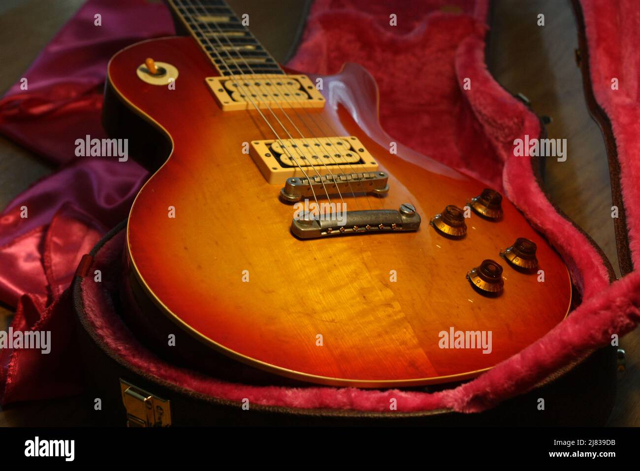 Photo du corps de guitare vintage les Paul, montrant l'usure de la laque.  La guitare est placée sur un boîtier bronzé avec un intérieur en feutre  rose Photo Stock - Alamy