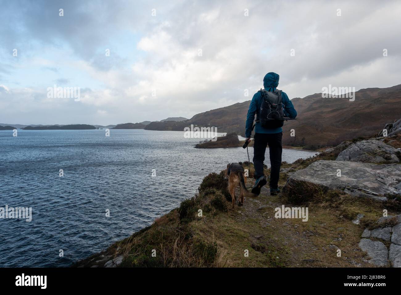 Paysages du Royaume-Uni: Personne marchant un chien allongisde Loch Morar près de Mallaig en hiver, Scottish Highlands, Écosse, Royaume-Uni Banque D'Images