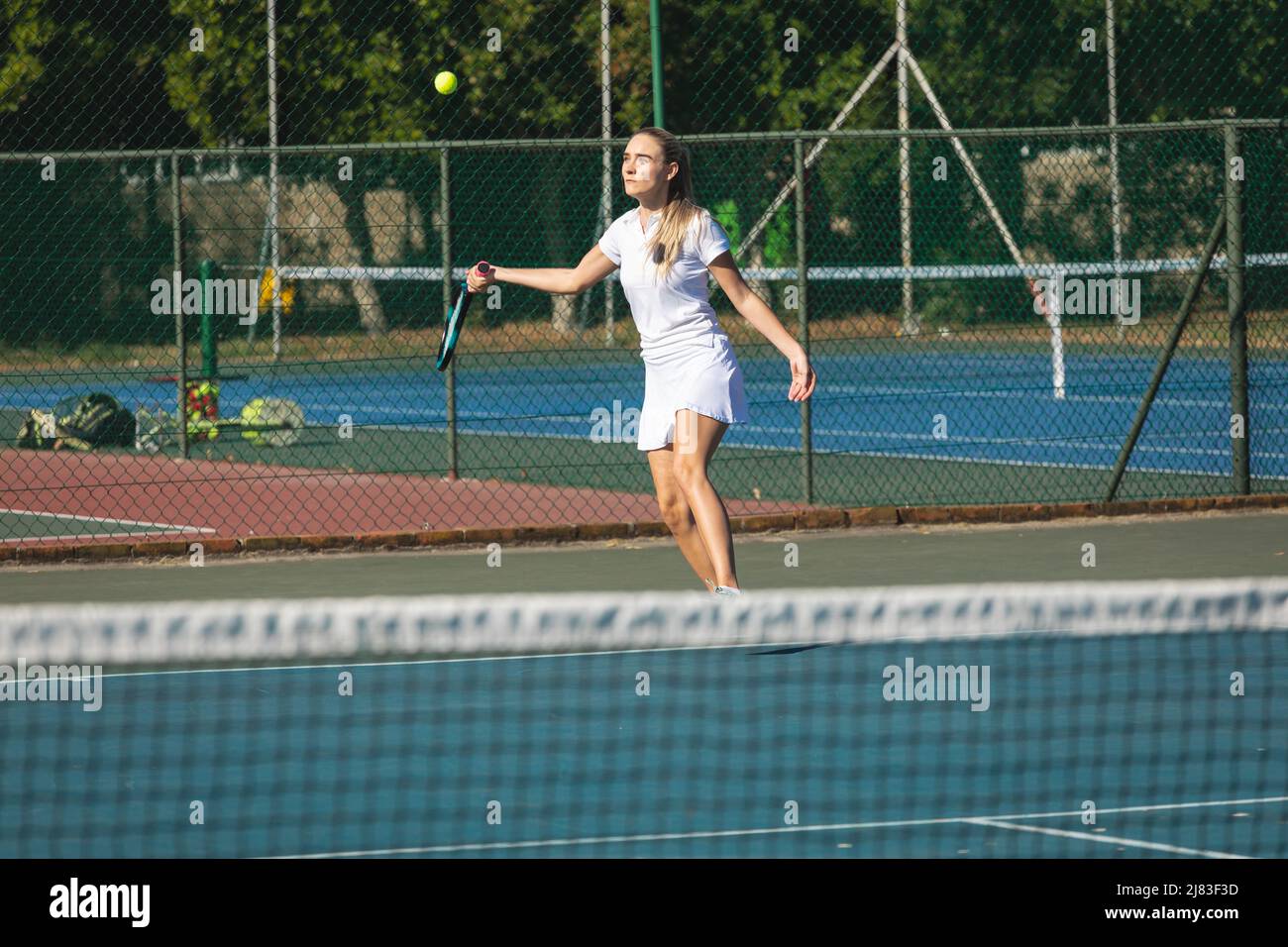 Une jeune joueuse de tennis caucasienne joue sur le terrain par beau temps Banque D'Images