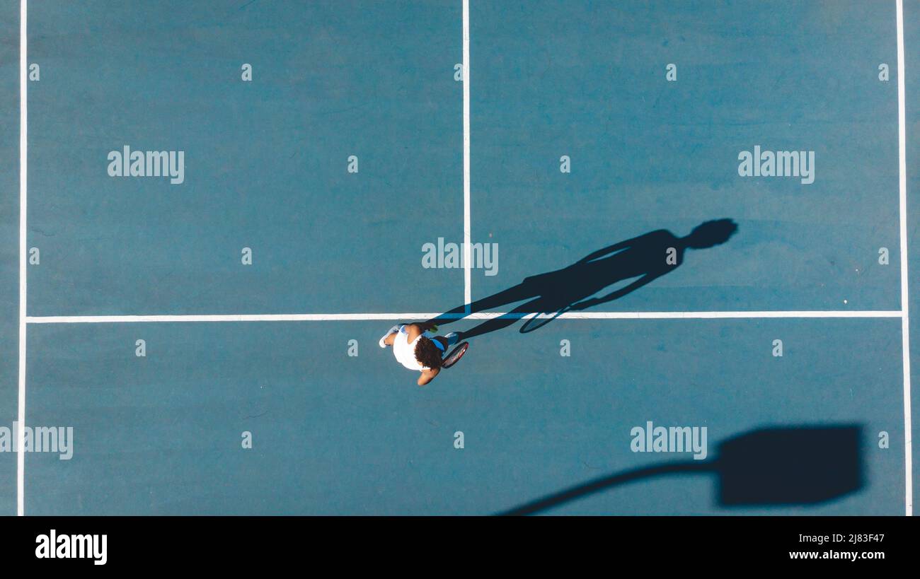 Directement au-dessus de la vue de la jeune femme afro-américaine jouant sur le court de tennis bleu Banque D'Images
