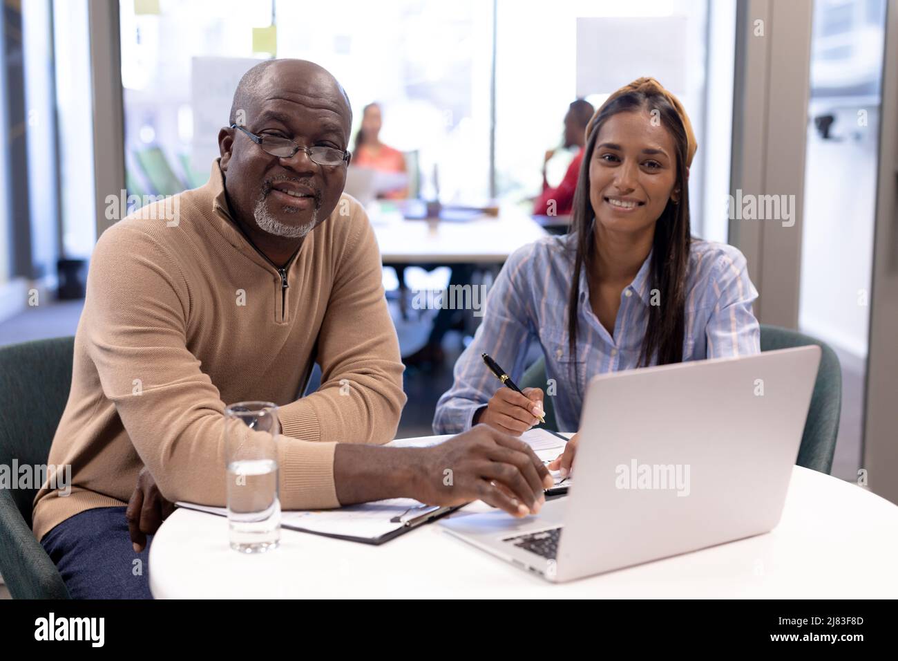 Portrait de collègues professionnels multiraciaux avec ordinateur portable assis dans la salle de réunion pendant la réunion Banque D'Images