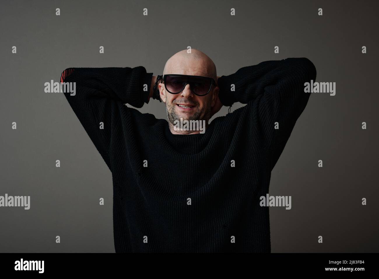 Portrait horizontal moyen d'un homme caucasien mûr et joyeux portant un pull élégant et des lunettes de soleil souriant à l'appareil photo Banque D'Images