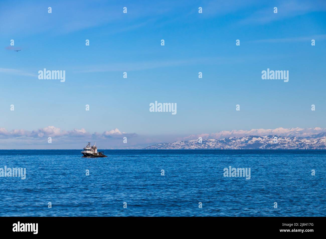 Arakli, Trabzon, bateau de pêche entre dans le port. Paysage de montagne enneigé est sur un fond Banque D'Images