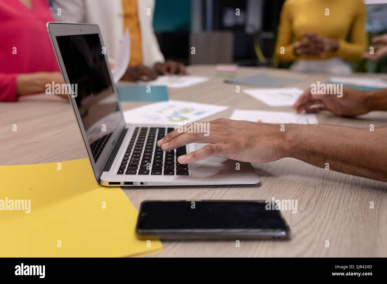 Main courte d'homme d'affaires hispanique utilisant un ordinateur portable à la table de conférence pendant la réunion avec des collègues Banque D'Images