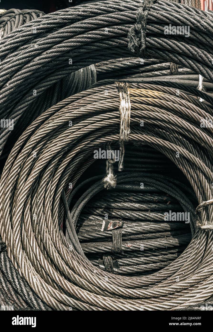 Bobines de grande élingue métallique ou de bobines de tambour d'élingue métallique stockées en magasin. Câble métallique ou corde en acier pour usage industriel lourd, texture du câble métallique, sélectif Banque D'Images