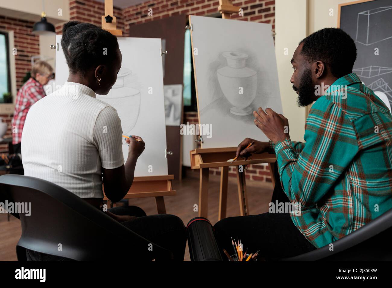 L'artiste s'assoit devant le modèle de vase à dessin en toile à l'aide d'un crayon graphique tout en attaquant la classe d'art en développant de nouvelles compétences artistiques pour la croissance personnelle. Concept Studio de créativité Banque D'Images