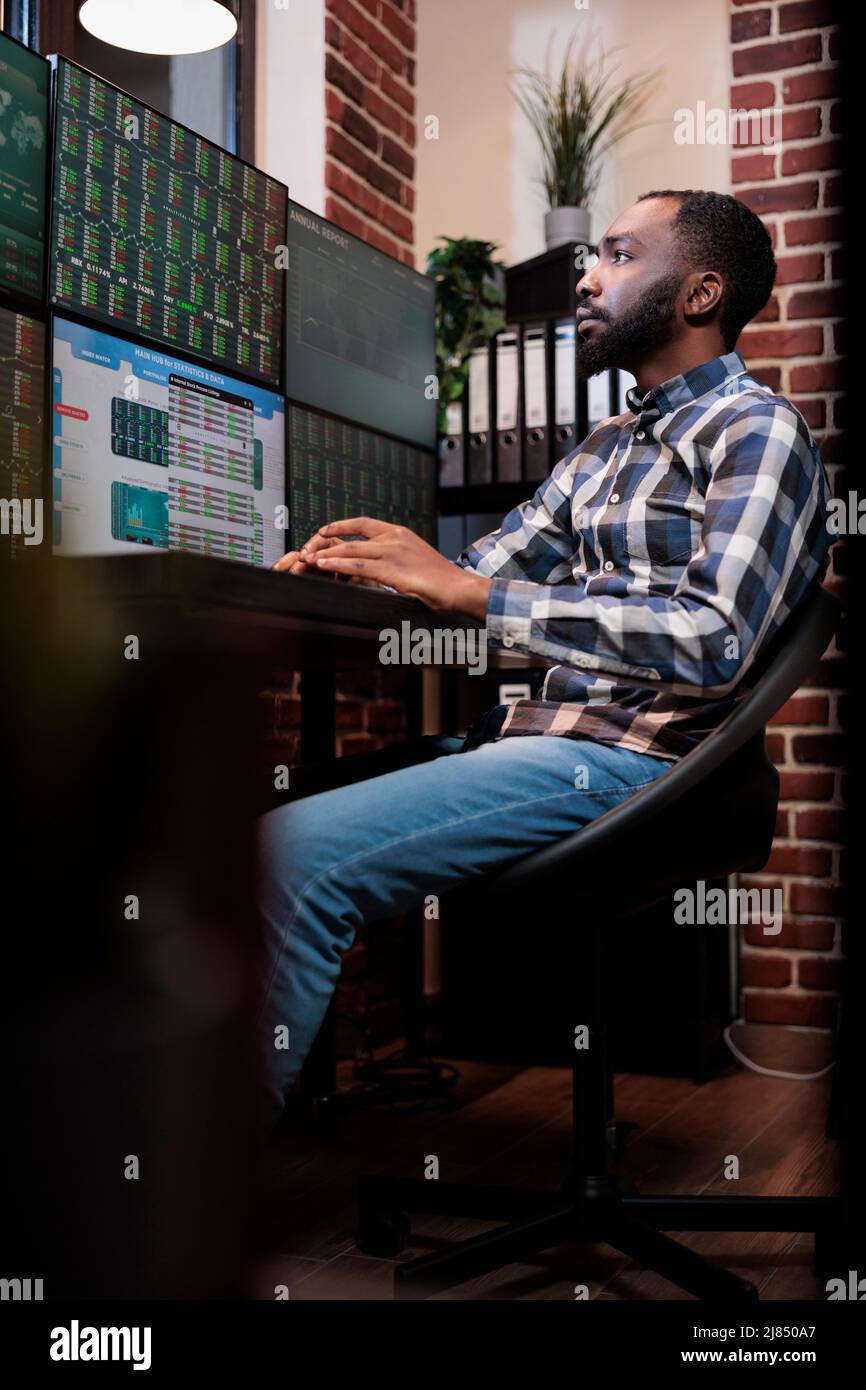 Agent commercial Forex assis au bureau avec poste de travail à plusieurs moniteurs tout en visualisant les données financières en temps réel sur les écrans. L'agent de la compagnie de fonds de couverture essayant de prévenir l'ours période du marché à l'aide de graphiques. Banque D'Images