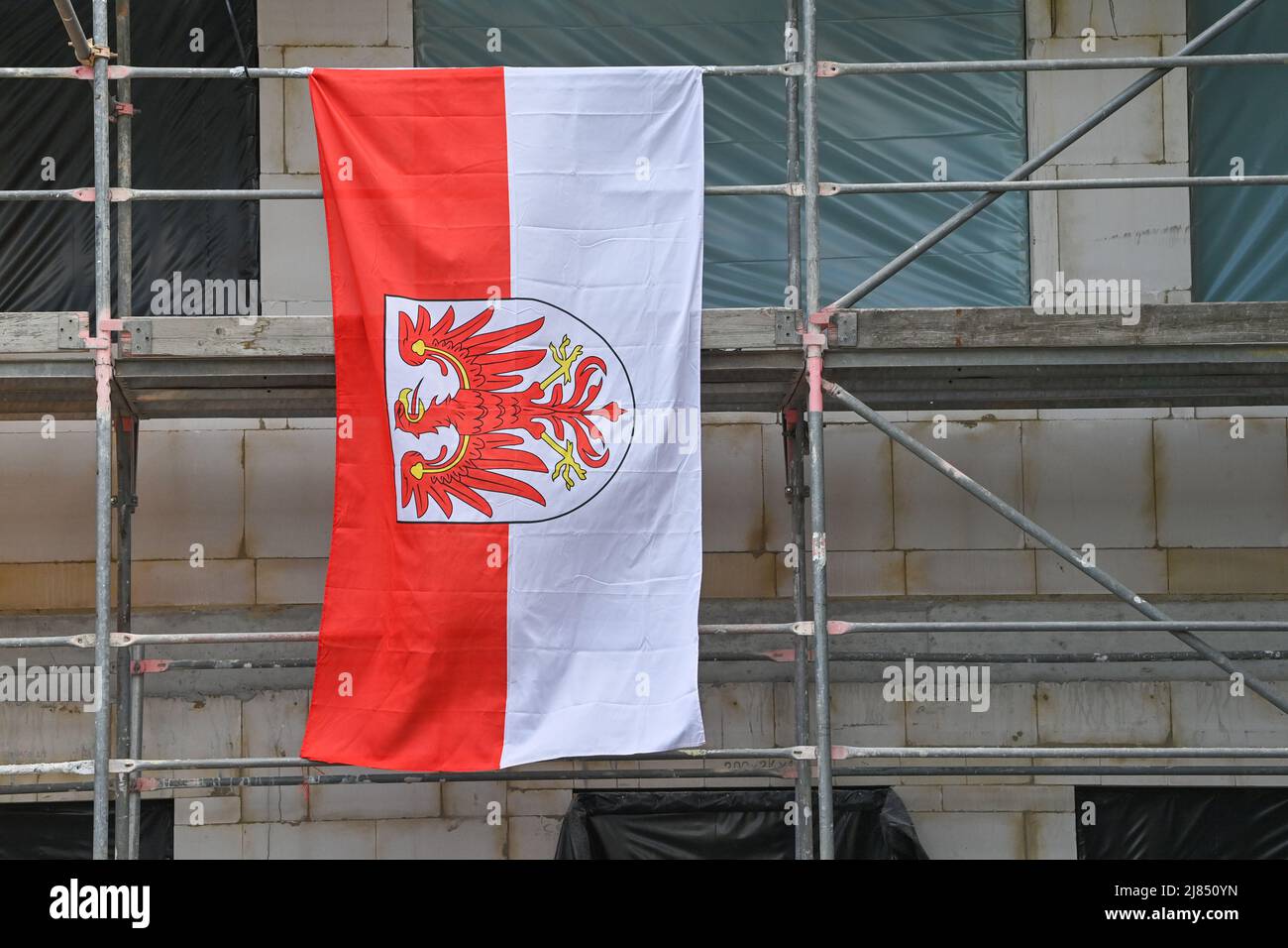 11 mai 2022, Brandebourg, Schönefeld: Le drapeau de l'état de Brandebourg est suspendu d'échafaudage à la cérémonie de la mise en place du nouveau bâtiment d'inspection de la police à l'aéroport de Berlin Brandenburg. Photo: Patrick Pleul/dpa Banque D'Images