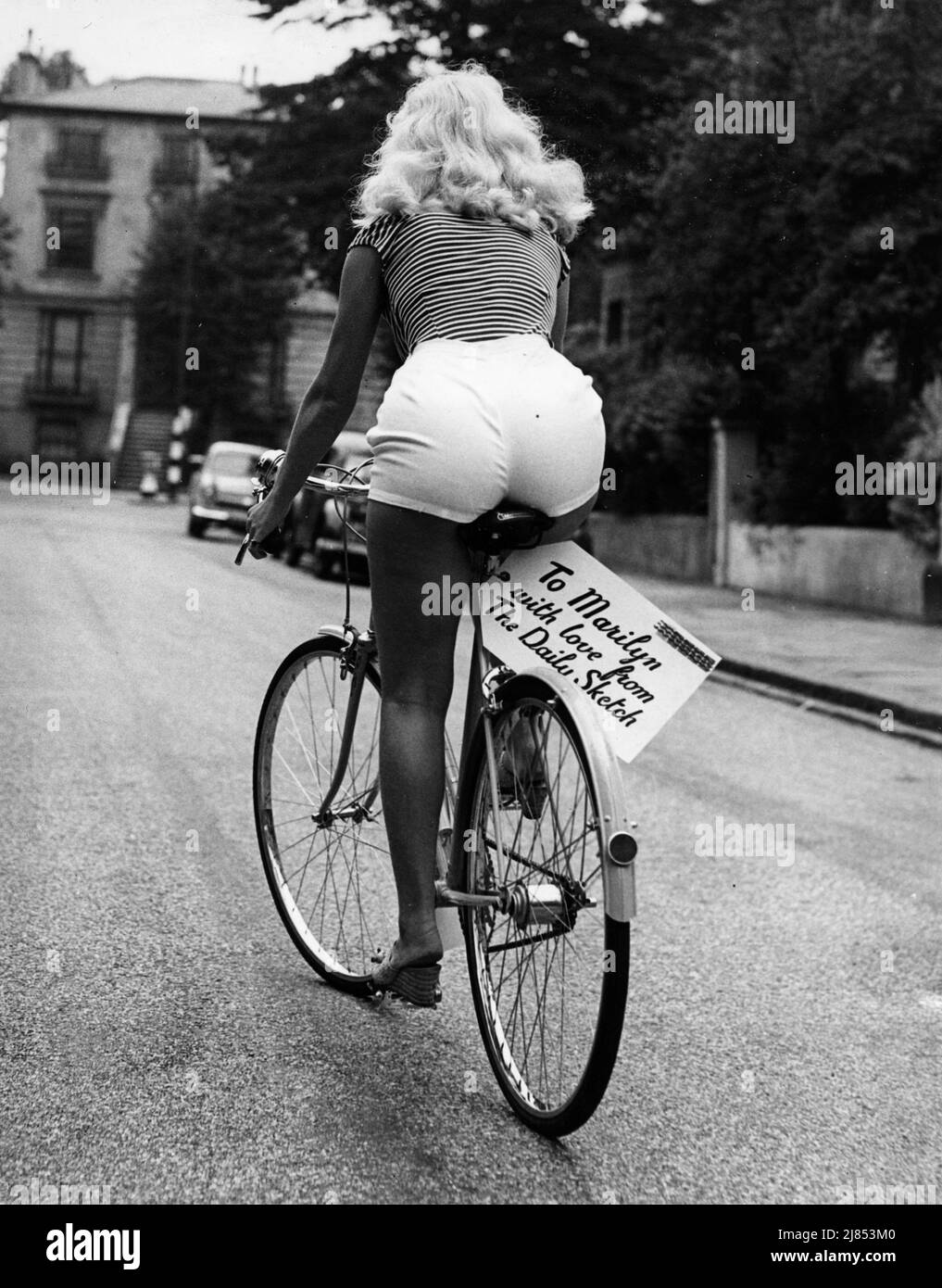 16 juillet 1956, Londres, Angleterre: Une femme blonde en short, roule sur un vélo qui a été présenté à Marilyn Monroe après qu'elle ait mentionné qu'elle voulait faire le tour de Surrey sur un cycle. Bike a un panneau attaché et dit: "À Marilyn avec amour de Daily Sketch." (Image de crédit : © Keystone Press Agency/ZUMA Press Wire) Banque D'Images