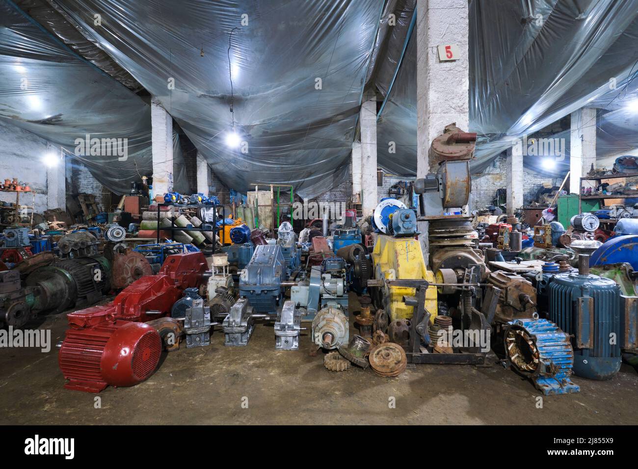 Anciennes pièces de machine à vendre dans un ancien entrepôt sombre. Sur le marché de Yangiobod Bozor à Tachkent, en Ouzbékistan. Banque D'Images