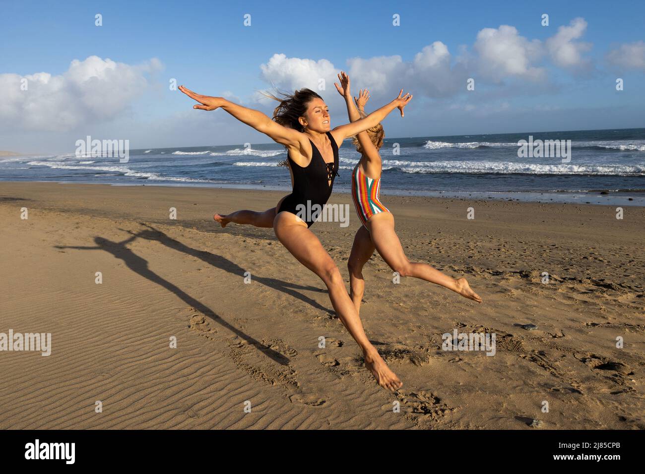 Libre les femmes sautant et s'amuser à la plage Banque D'Images