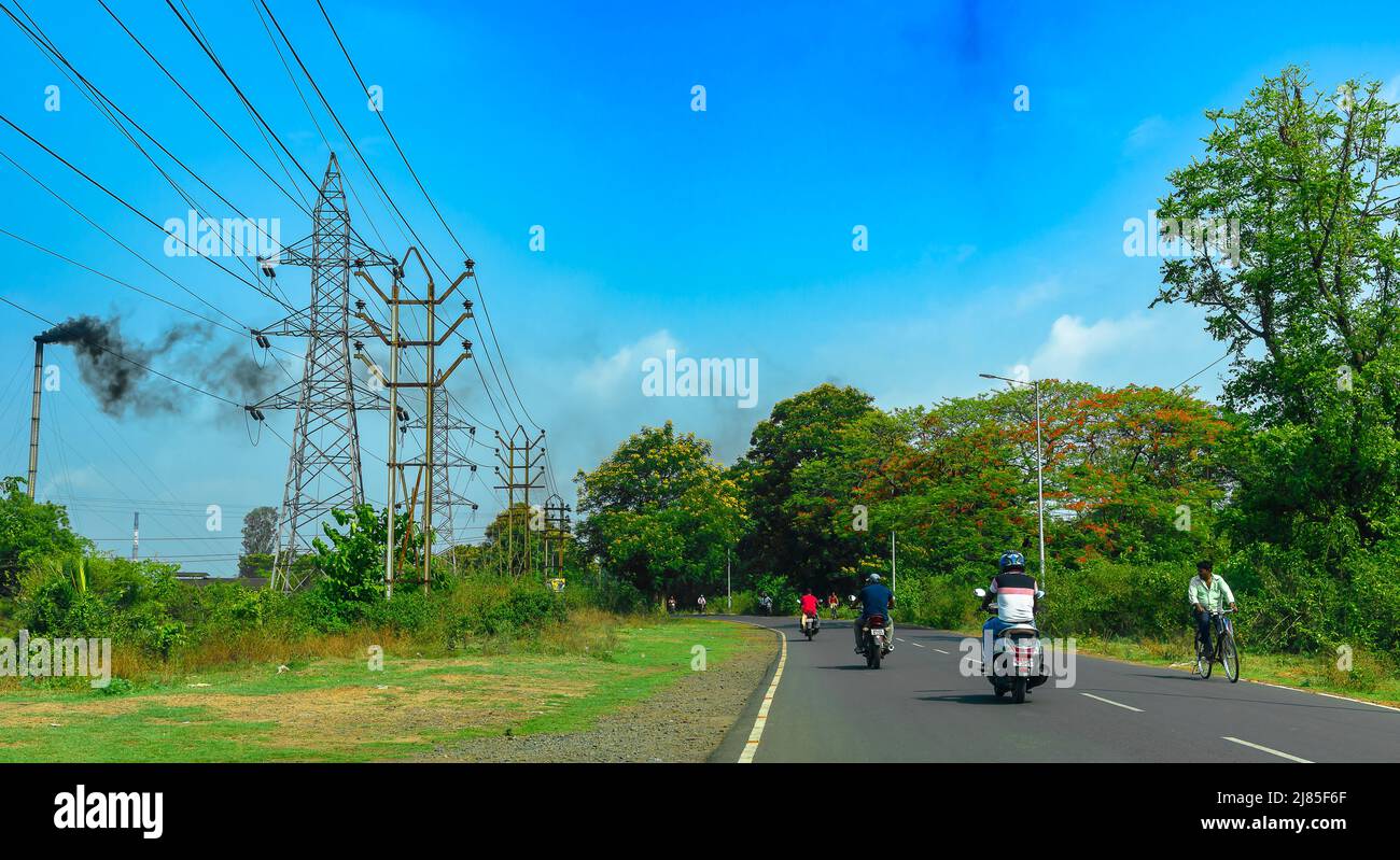 Durgapur, Inde, mai 12,2022: Circulation urbaine avec pollution émis usine Chimney. La mise au point sélective est utilisée. Banque D'Images