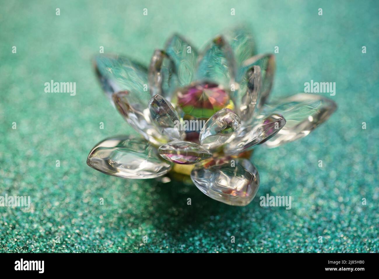 Lotus cristal sur une surface vert brillant. Symbole du bouton du paradis. Banque D'Images