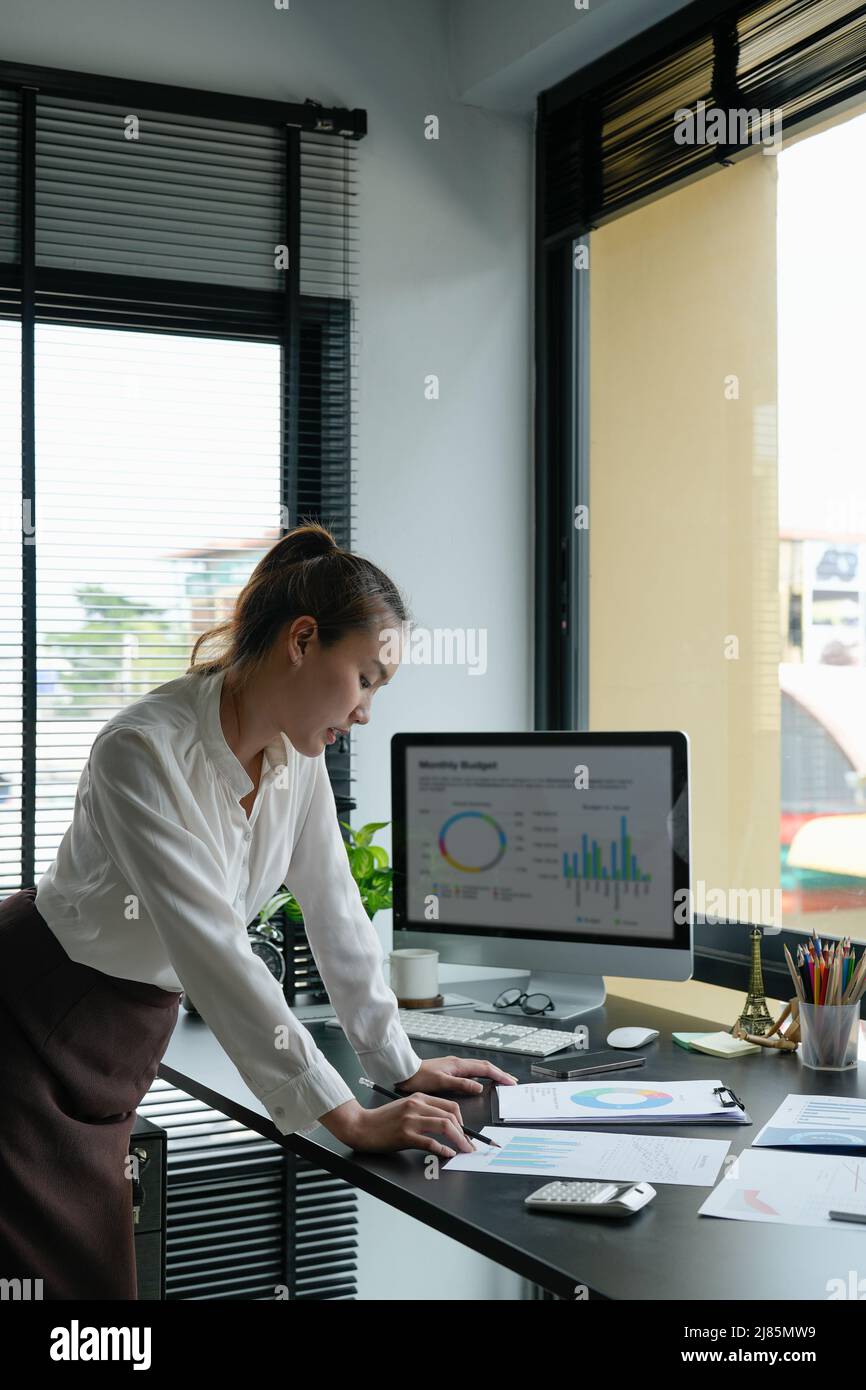 Femme d'affaires utilisant la calculatrice pour faire des finances mathématiques sur le bureau en bois dans le bureau et les affaires de travail, la fiscalité, la comptabilité, les statistiques et l'analytique Banque D'Images