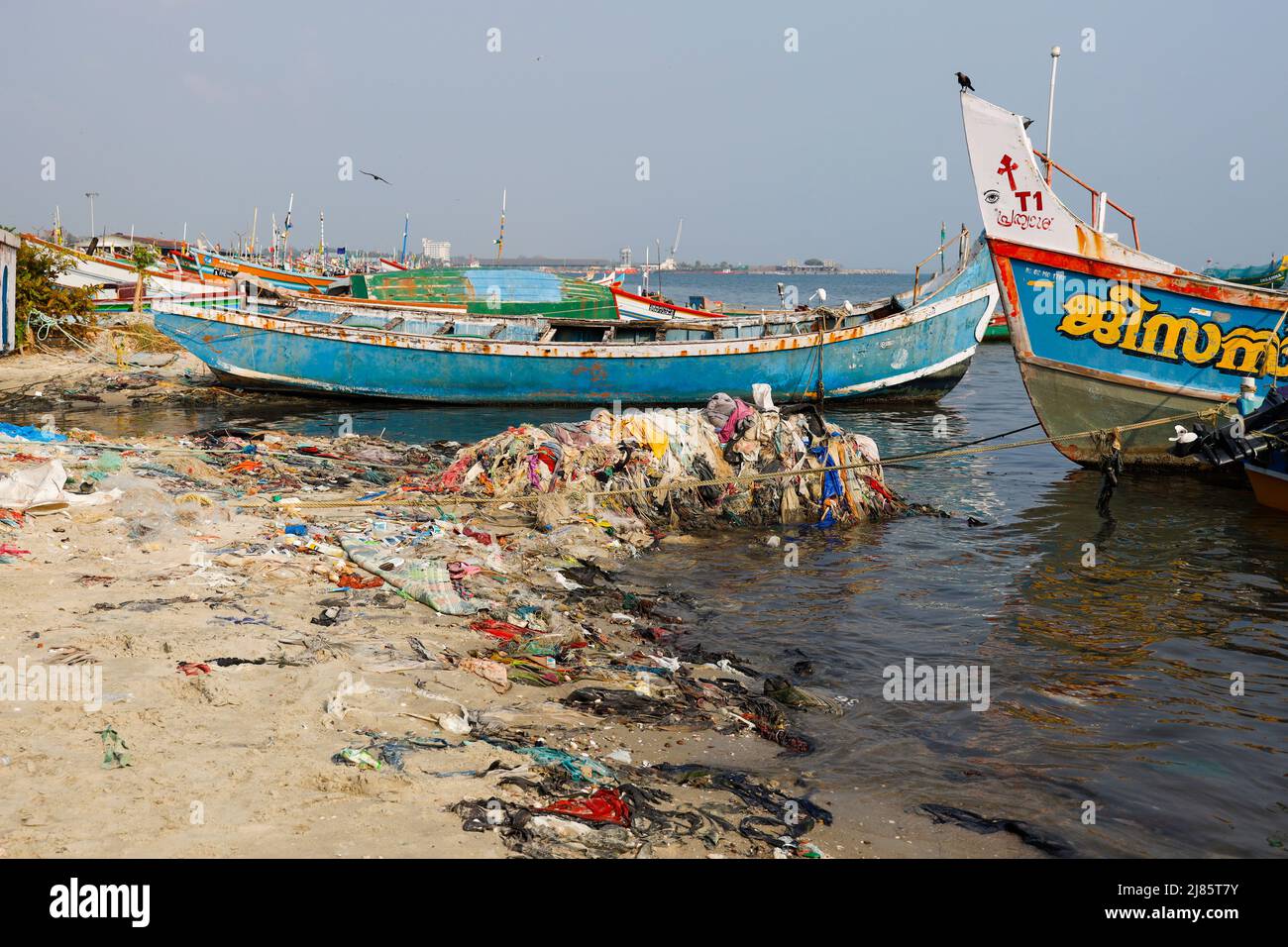 Des tas de déchets sur la plage à côté des bateaux de pêche à Tangassery, Thangassery, Kerala, Inde. Banque D'Images