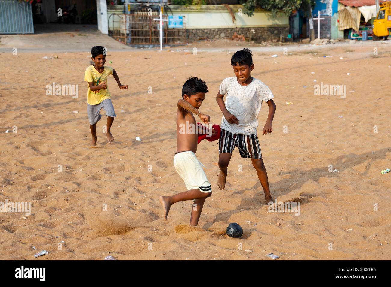 Trois jeunes garçons jouant au football avec une balle auto-fabriquée à Tangassery, Thangassery, Kerala, Inde. Banque D'Images