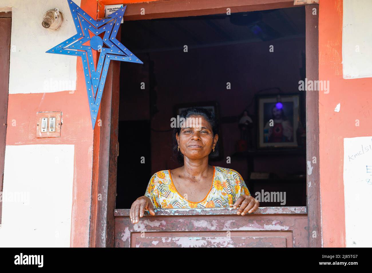 Portrait d'une femme locale debout à la porte de sa maison à Tangassery, Thangassery, Kerala, Inde. Banque D'Images