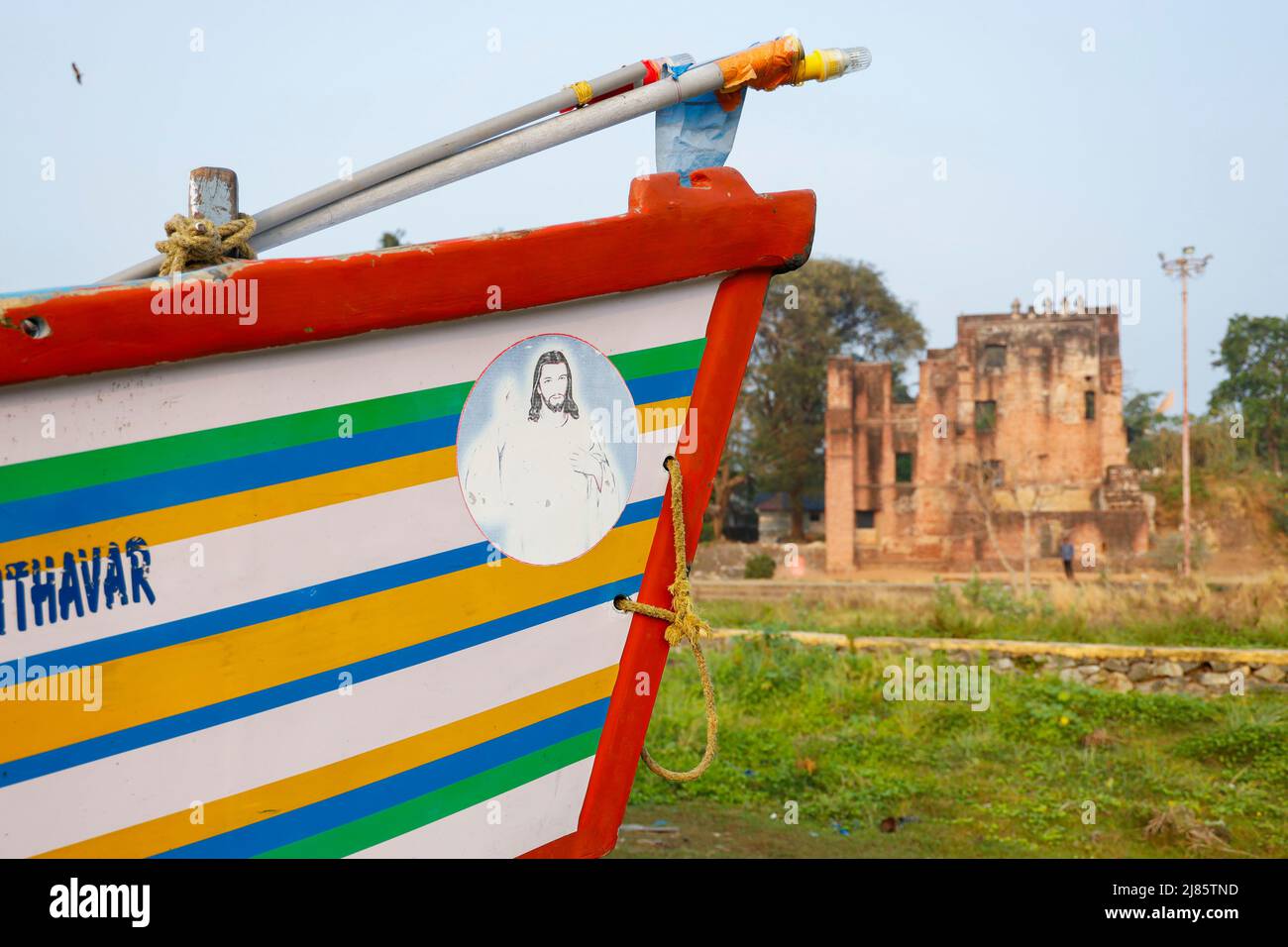 Arc d'un bateau de pêche avec les ruines du fort de St.Thomas en arrière-plan, Tangassery, Thangassery, Kerala, Inde. Banque D'Images