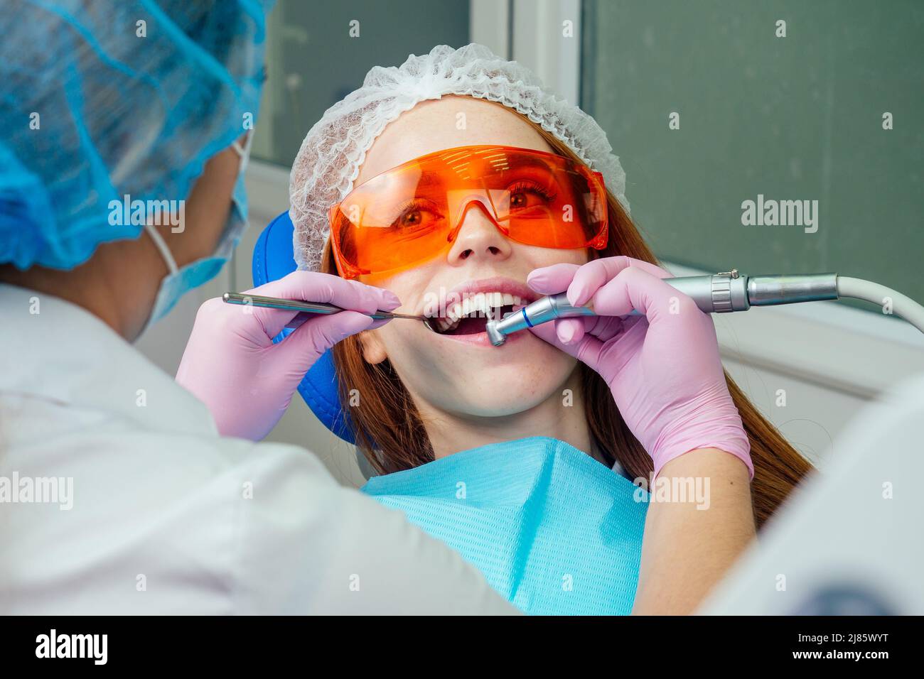Portrait d'une belle fille client souriante au gingembre rougeâprée dans une chaise dentaire dans un cabinet dentaire.elle n'est pas peur Banque D'Images