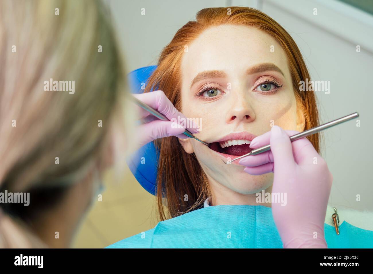 Portrait d'une belle fille client souriante au gingembre rougeâprée dans une chaise dentaire dans un cabinet dentaire.elle n'est pas peur Banque D'Images