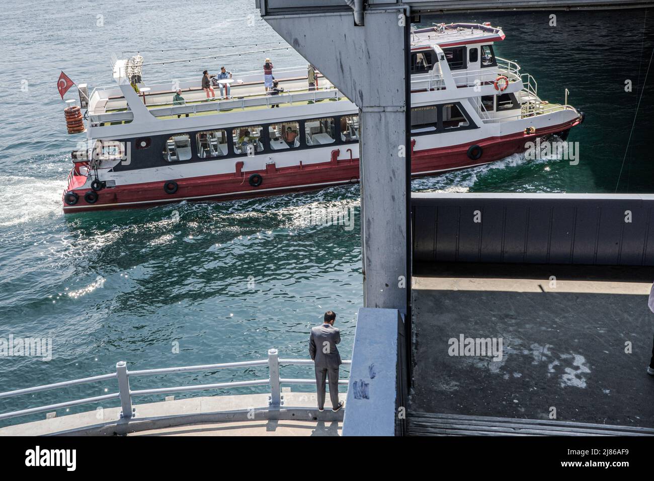 Un ferry est vu en passant sous le pont de Galata. Le transport maritime par ferry est une spécificité d'Istanbul. Malgré le tunnel le plus profond du monde sous le Bosphore pour le métro et l'inauguration du nouveau 'Canakkale 1915 Bridge' en mars 2022, la population et les 2019 nouveaux élus maire d'Istanbul font la promotion du transport maritime pour soulager la circulation routière et réduire les émissions de CO2. Banque D'Images