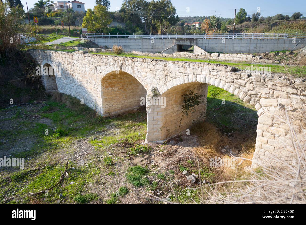 Un pont en pierre médiéval construit en pierre courgée en premier plan avec un pont routier moderne en arrière-plan. Banque D'Images