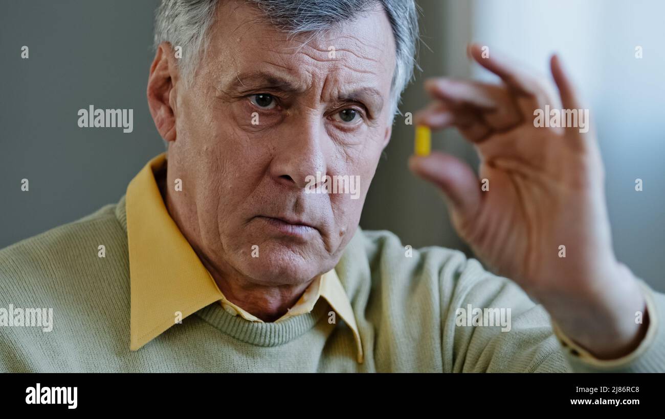 Malsain vieux senior retraité mâle Caucasien malade malade 60s grand-père homme tient la pilule avec la médecine analgésique remède cardiologique de médicament Banque D'Images