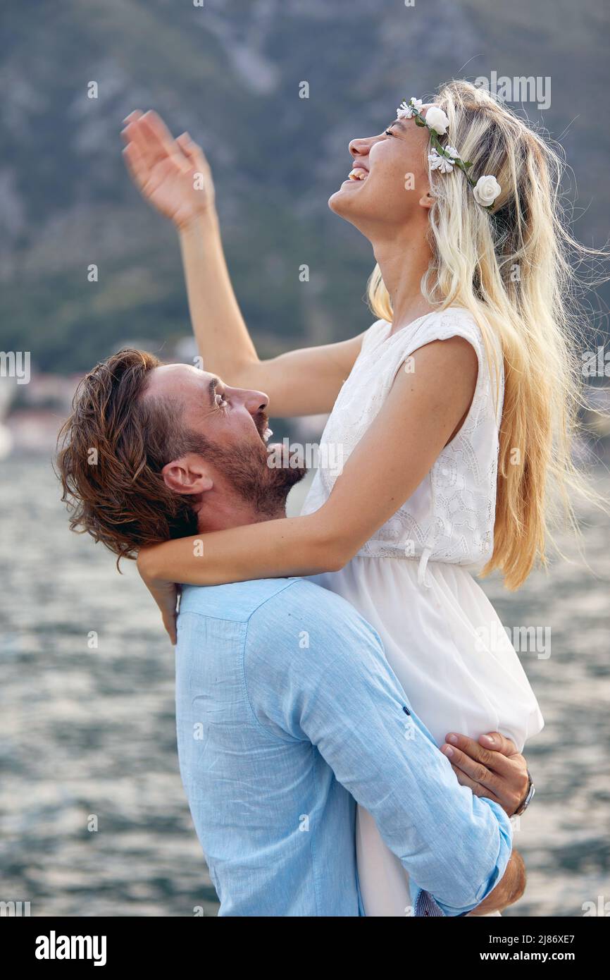 Vue rapprochée d'un jeune homme tenant sa petite amie dans les bras pendant qu'ils ont un bon moment sur une belle journée en bord de mer. Amour, relation, holoïde Banque D'Images