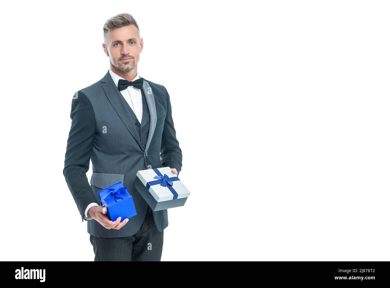 homme d'affaires souriant en tuxedo avec boîte isolée sur blanc. jour de boxe Banque D'Images