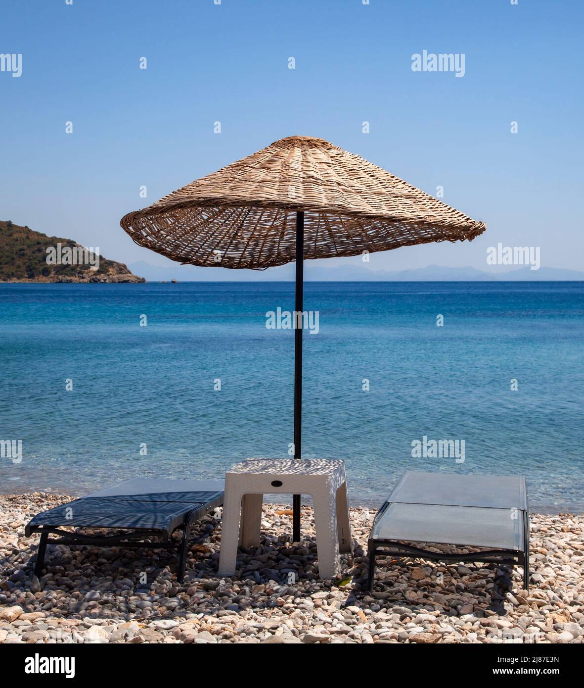 Parasol en osier et deux chaises longues vides sur la plage. Concept de vacances. Paysage. Banque D'Images