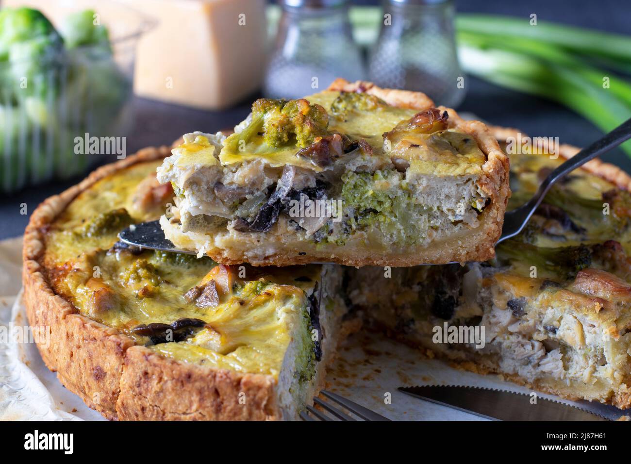Quiche au poulet, aux champignons, au brocoli et au fromage, tarte française traditionnelle maison avec un morceau de coupe Banque D'Images