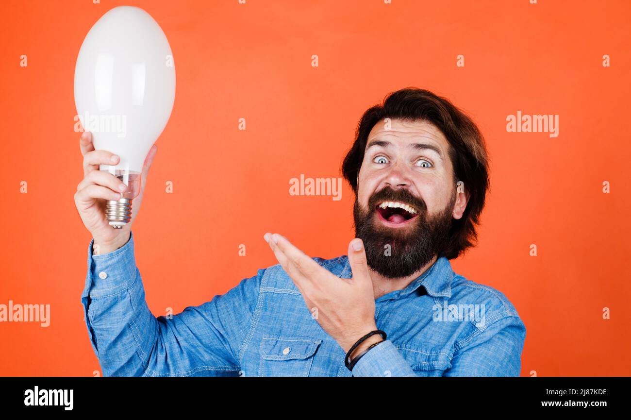 Homme souriant avec ampoule. Énergie et électricité. Service de mise au rebut. Innovation et inspiration Banque D'Images