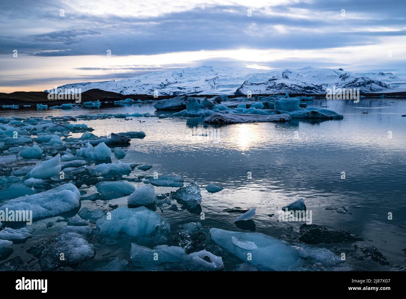Vue panoramique sur les icebergs dans la lagune de glacier de Jökulsárlón sous un ciel spectaculaire, Öræfajökull dans le backgroung, Islande Banque D'Images