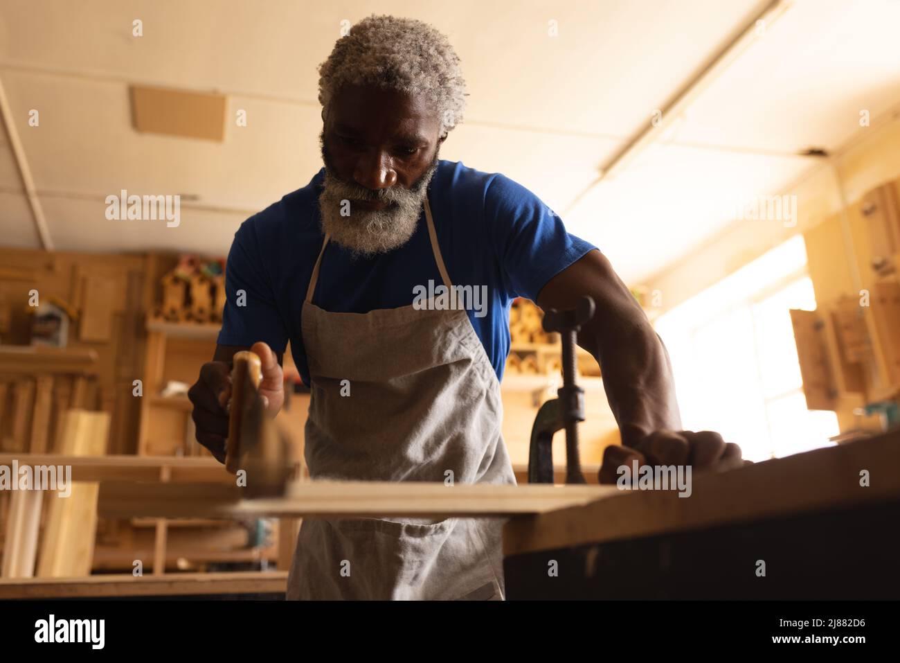 Charpentier africain américain mature lame de coupe avec scie en atelier Banque D'Images