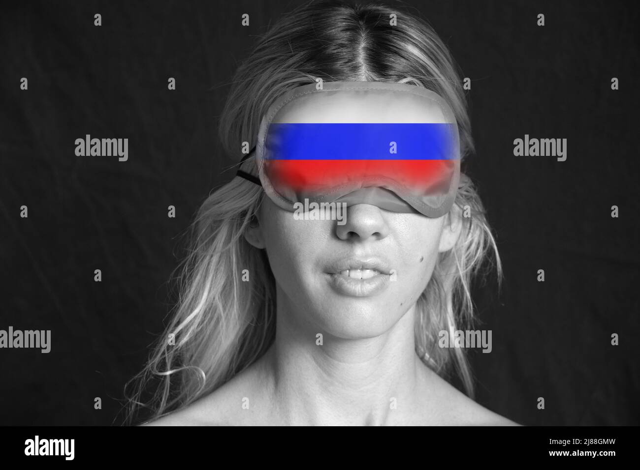 Une jeune fille avec un masque sur un galaza avec un drapeau peint de la Russie, la propagande russe fermé les yeux des gens à la vérité, arrêter la guerre en Ukraine 2022 Banque D'Images