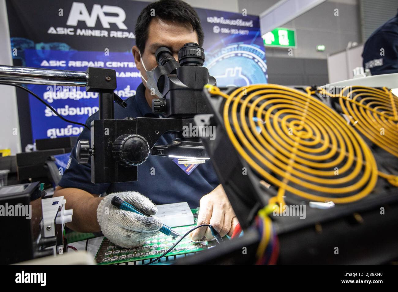 Bangkok, Thaïlande. 14th mai 2022. Un membre du personnel répare une carte mère de mineur au stand de réparation de mineur ASIC au salon Thailand Crypto Expo 2022 au centre international de commerce et d'exposition de Bangkok (BITEC) le 14 mai 2022 à Bangkok, Thaïlande. Crédit : SOPA Images Limited/Alamy Live News Banque D'Images