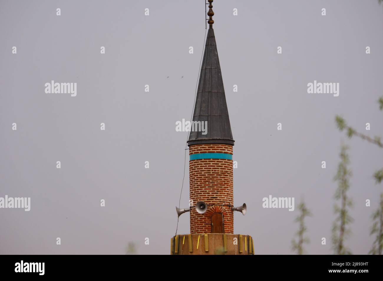 Minaret historique en pierre de style ottoman par temps sombre et nuageux Banque D'Images