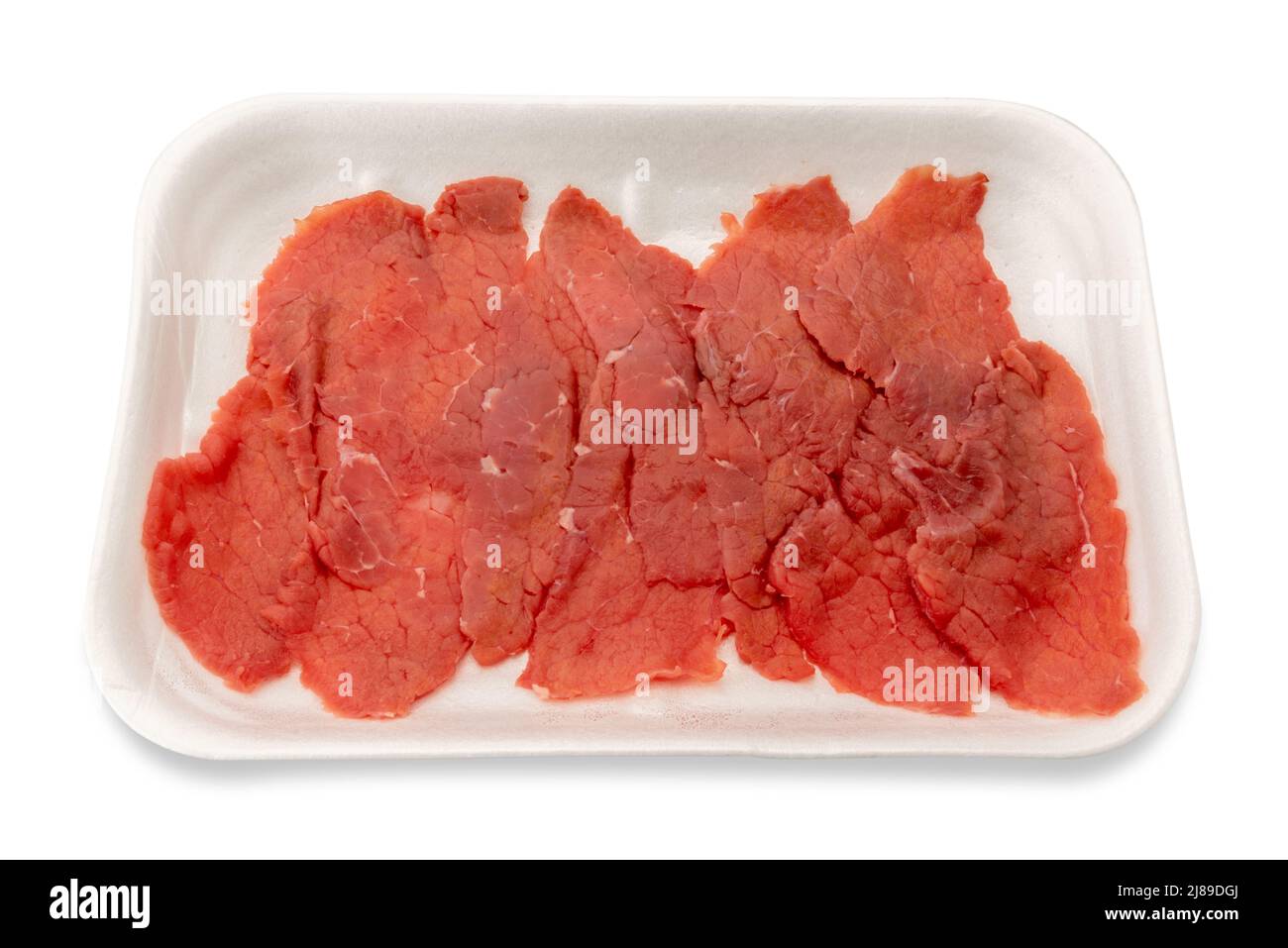 Émincé de bœuf cru pour carpaccio italien dans un plateau en plastique alimentaire à vendre. Isolé sur blanc. Masque Banque D'Images