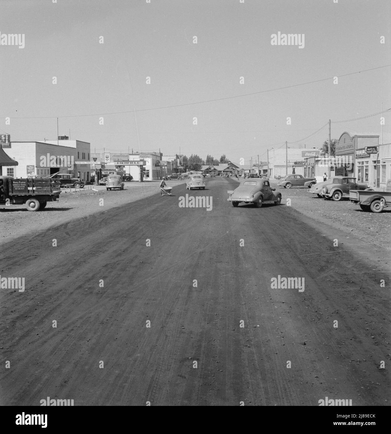 Californie Siskiyou Comté, Tulelake. Vue sur la rue principale d'une ville frontalière, encore malvoyante. Cette ville n'a pas d'eau potable. [Panneaux: 'Produits pétroliers standard; Richfield; Casino; Coca-Cola; magasins fédérés; Produits secs; Mildred's Beauty salon']. Banque D'Images